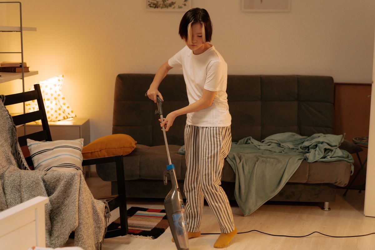 Woman vacuuming a living room floor at home